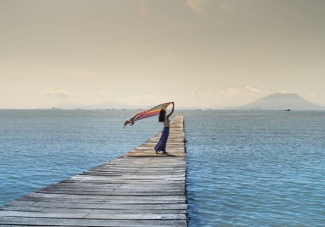 A woman is doing yoga on the pier